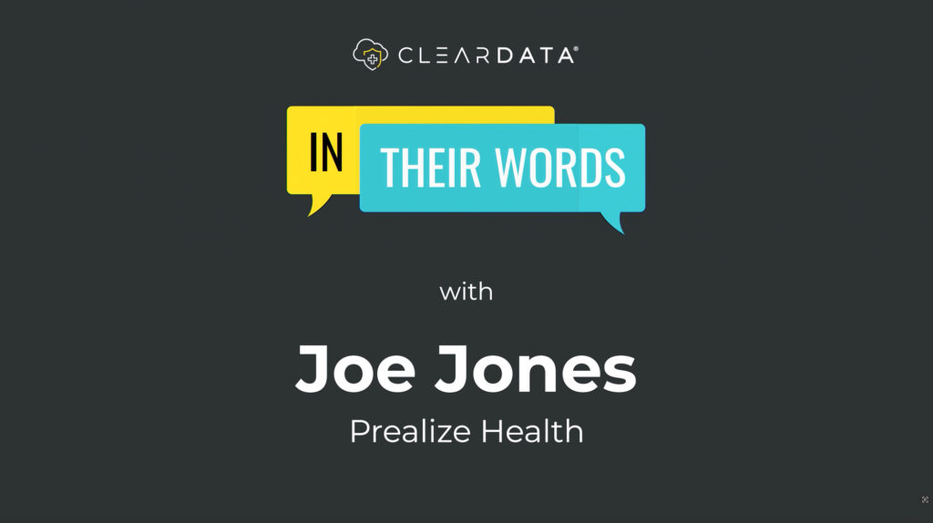 The image shows a title card or presentation slide with a dark gray background. At the top is the ClearData logo. Below that is a graphic with two speech bubbles - a yellow one containing "IN" and a teal one containing "THEIR WORDS" - creating the title "IN THEIR WORDS." Beneath this graphic, it states "with" followed by "Joe Jones" in large white text, and "Prealize Health" in smaller white text. introductory slide for an interview or testimonial featuring Joe Jones from Prealize Health.